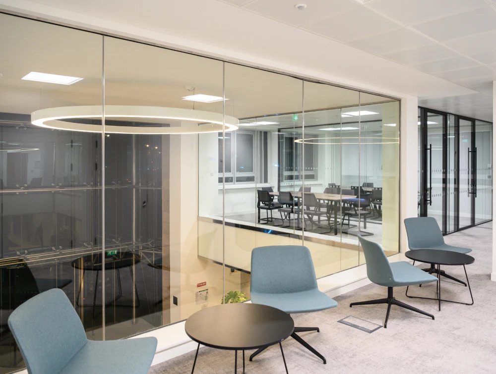 Round-Coffee-Table-in-Black-Finish-with-Lounge-Chair-in-Breakout-Setting